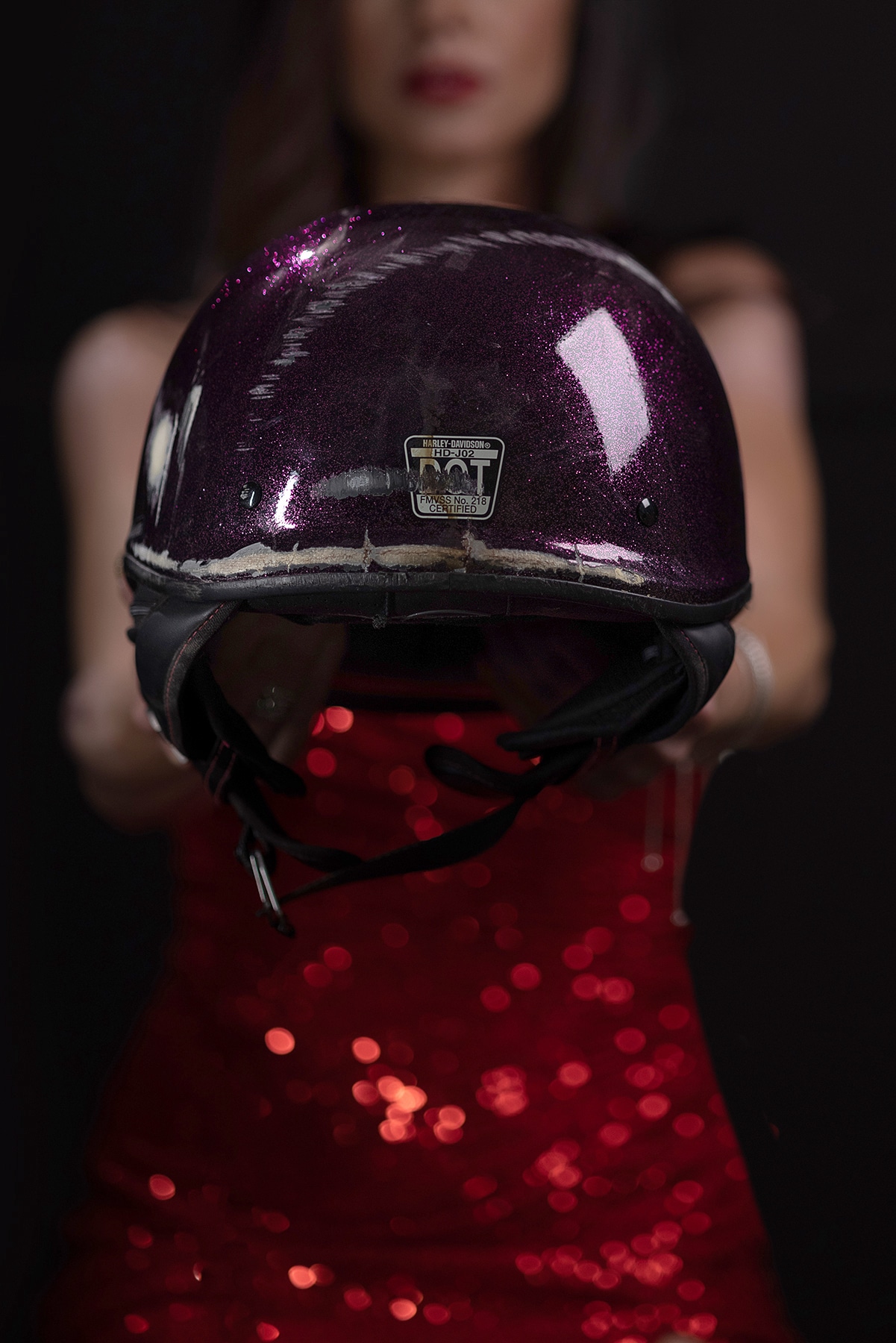 Woman in red gown holding helmet that saved her life. Shannon Hemauer Photography